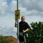Martin Cartwright placing one of the new 120 Groby Neighbourhood Watch Signs.